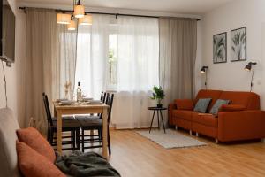 ein Wohnzimmer mit einem orangenen Sofa und einem Tisch in der Unterkunft Fresh Apartment with Terrace + Free Parking in Graz