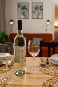 a bottle of wine sitting on a table with two glasses at Fresh Apartment with Terrace + Free Parking in Graz