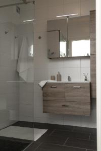 a bathroom with a sink and a mirror at Fresh Apartment with Terrace + Free Parking in Graz