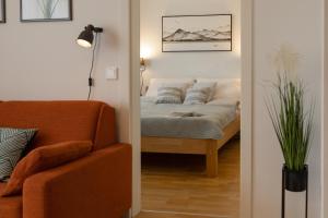 ein Schlafzimmer mit einem Bett, einem Sofa und einer Lampe in der Unterkunft Fresh Apartment with Terrace + Free Parking in Graz