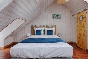 ein Schlafzimmer mit einem großen Bett im Dachgeschoss in der Unterkunft Maison de ville Bayeux in Bayeux