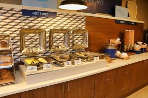 a bakery counter with many trays of pastries at Holiday Inn Express, an IHG Hotel in Douglas