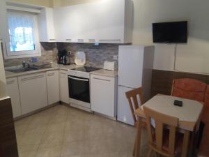 a kitchen with white appliances and a table and a table and chairs at Sofia & Lakis House in Ormos Panagias