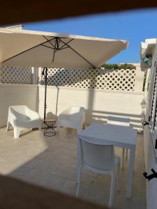 a patio with a table and two chairs and an umbrella at SEASIDE Temporary House in Leporano Marina