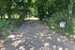 a dirt road with trees on either side at Gîte L'évidence in Saint-Caradec-Trégomel