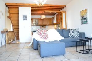 a living room with a blue couch and a kitchen at Akti Posidonos in Elounda