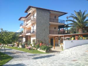 a large apartment building with balconies on a street at Sofia & Lakis House in Ormos Panagias