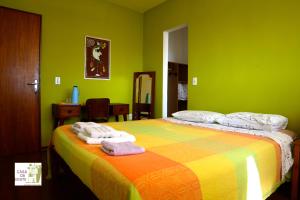 Un dormitorio verde con una cama con toallas. en Casa da Gente, en Río de Janeiro