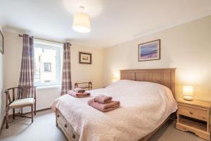 1 dormitorio con 1 cama con toallas en Creel Cottage, en Eyemouth