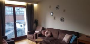 ein Wohnzimmer mit einem Sofa und einem großen Fenster in der Unterkunft Norblin Apart in Warschau
