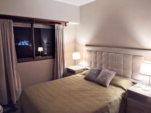 a bedroom with a bed with two lamps and a window at VISTAS DEL GOLF in Mar del Plata