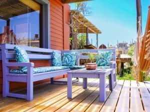 a porch with a blue bench and a table at Cabañas Kundalini Punta del Diablo in Punta Del Diablo