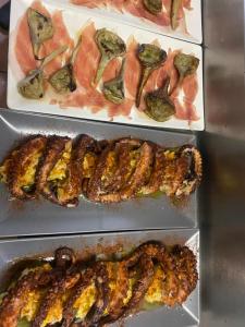 três bandejas de alimentos com diferentes tipos de carne em Restaurant & Rooms Cabrit em Sant Mateu