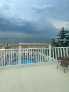 a balcony with a white fence and the beach at Driftwood Motel in Point Pleasant Beach