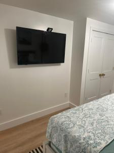 a bedroom with a flat screen tv on the wall at Driftwood Motel in Point Pleasant Beach