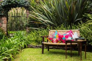 a garden bench with a table and pillows on it at Casa Magdalena Hotel Boutique in Morelia