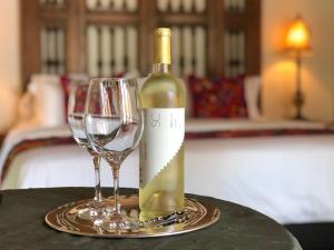 a bottle of wine and two wine glasses on a table at Casa Magdalena Hotel Boutique in Morelia