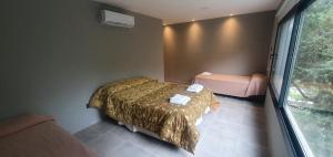 una piccola camera da letto con un letto e una finestra di Cabaña con Pileta Sobre Camino Del Cuadrado En La Montaña Con Vistas Increíbles - Cerca De Todo a Río Ceballos