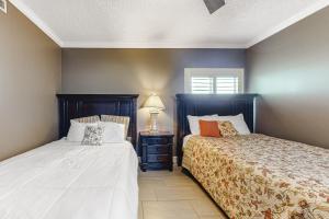 a bedroom with two beds and a table with a lamp at Ocean's Edge 302 in Ocean City