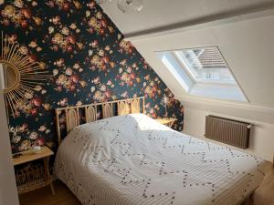 a bedroom with a large bed with floral wallpaper at Havre d'amour in Mondeville