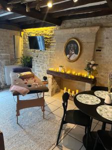 a living room with a fireplace and a table and chairs at Havre d'amour in Mondeville