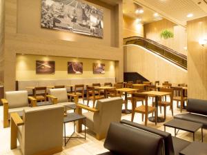 a restaurant with tables and chairs and a staircase at Hotel Royal Morioka in Morioka