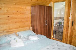 莫伊科瓦茨的住宿－Tara Valley Eco Lounge，一间卧室配有一张木墙床