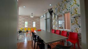 a dining room with a wooden table and red chairs at Rumah Familiku 1 Syariah in Wonocolo