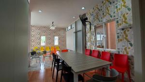 uma sala de jantar com uma mesa de madeira e cadeiras vermelhas em Rumah Familiku 1 Syariah em Wonocolo
