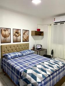 a bedroom with a blue and white bed and a desk at Apto no centro perto do Shopping com 2 Quartos ArCond WiFi Fibra HomeOffice e Garagem em Dourados in Dourados