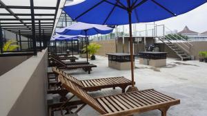 a row of benches with umbrellas on a building at Rumah Familiku 1 Syariah in Wonocolo +18 photos