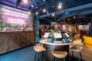 a restaurant with stools and a table with clocks on it at YOTEL Manchester Deansgate in Manchester