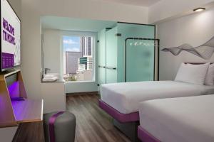 a hotel room with two beds and a window at YOTEL Miami in Miami