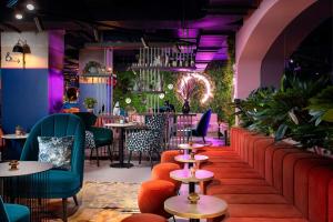 a restaurant with tables and chairs and plants at YOTEL Manchester Deansgate in Manchester