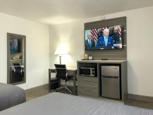 a hotel room with a flat screen tv on the wall at Money Saver Motel in Newport