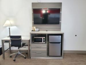 a desk with a television and a chair in a room at Seven Seas Inn & Suites in Newport