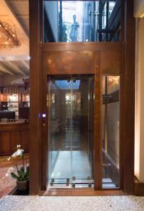 an elevator in a building with glass doors at Hotel Santa Marta Suites in Milan