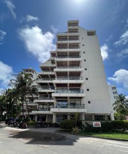 un edificio blanco alto con motos estacionadas frente a él en Edificio Bay Point Apartmento 307, en San Andrés