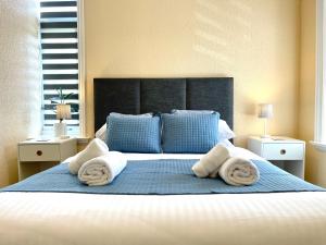 1 dormitorio con 1 cama grande y toallas. en Modern Family Apartment FREE Parking and Gym by Beach en Bournemouth