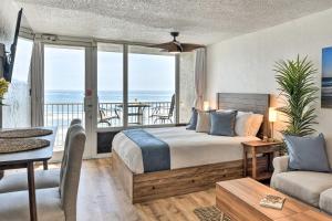 a bedroom with a bed and a balcony with the ocean at Oceanfront, Fourth-Floor Condo on Daytona Beach! in Daytona Beach