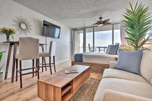 a living room with a couch and a bed and a table at Oceanfront, Fourth-Floor Condo on Daytona Beach! in Daytona Beach