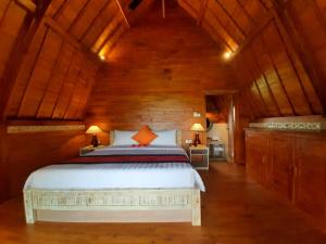 sypialnia z łóżkiem i drewnianym sufitem w obiekcie Pondok Gandalangu Ubud-Dikelilingi Hamparan Sawah w mieście Ubud