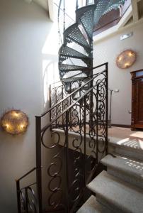 a spiral staircase with wrought iron railings and lights at Hotel Santa Marta Suites in Milan