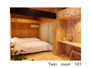 a bedroom with a bed in a wooden wall at 古民家一棟貸し 加持ノ宿 高知県幡多郡黒潮町 