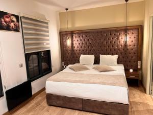 a bedroom with a large bed with a wooden headboard at Paris Luxury Guest House - CDG Aéroport in Roissy-en-France