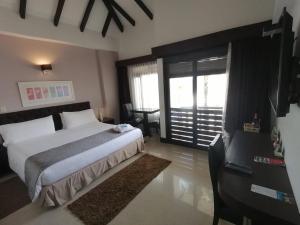 a bedroom with a large bed and a large window at Santa Maria de Leyva hotel boutique in Villa de Leyva