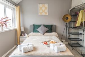 a bedroom with a bed with towels and a tray of food at Idyllic 3-bed House. 5-min from Channel Tunnel in Folkestone