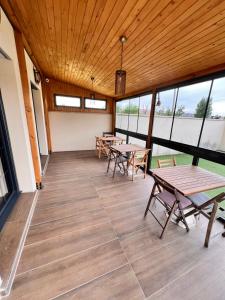 Zimmer mit Tischen, Stühlen und Fenstern in der Unterkunft Paris Luxury Guest House - CDG Aéroport in Roissy-en-France