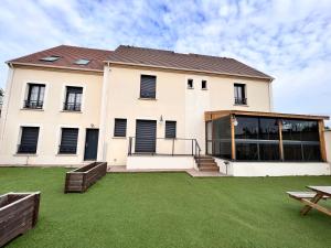 a house with a lawn in front of it at Paris Luxury Guest House - CDG Aéroport in Roissy-en-France