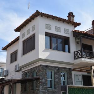 uma casa branca com janelas pretas em Mamadinas House AlliMpanta em Ammouliani